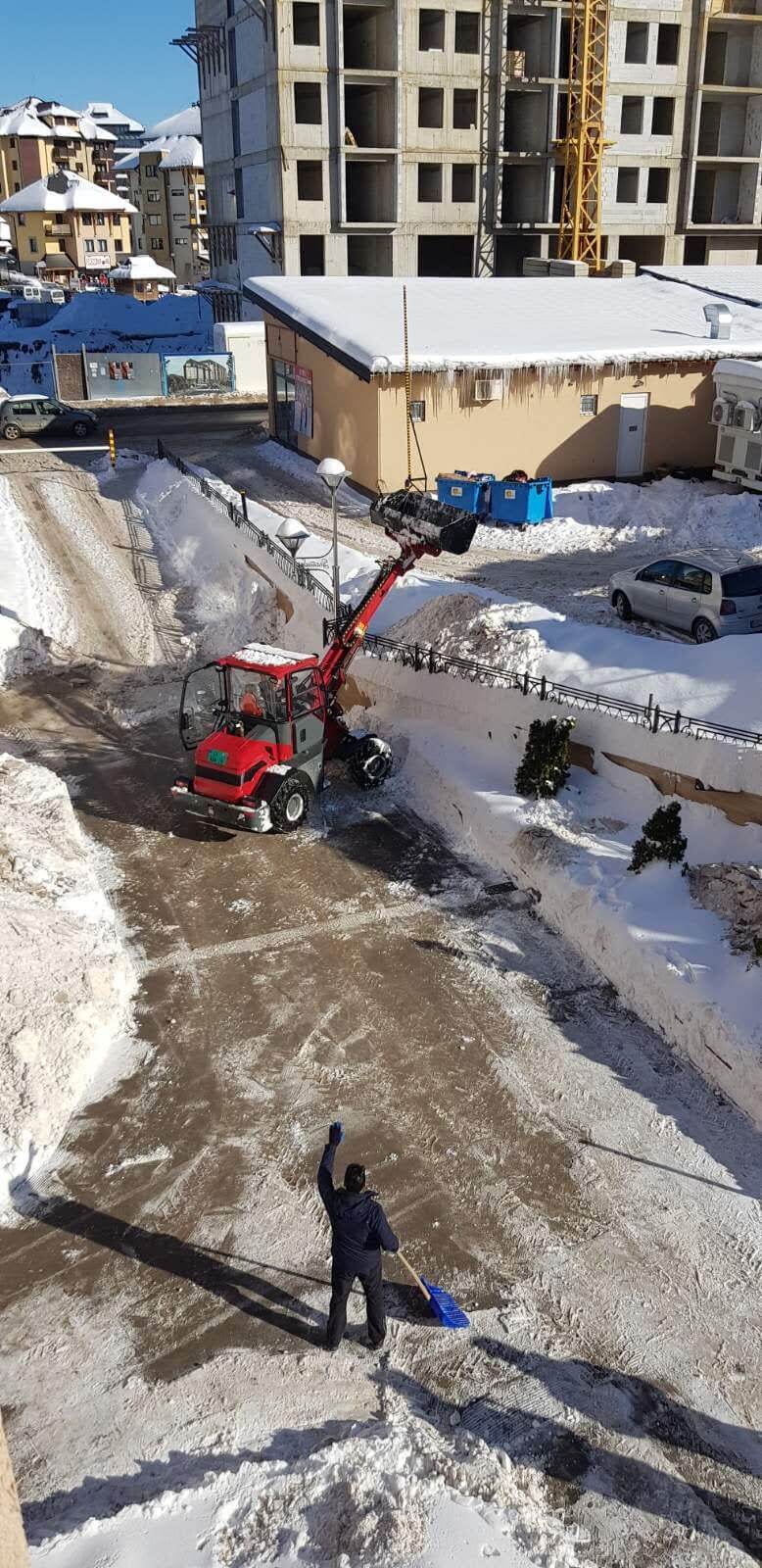 Kvad čisti sneg ispred zgrade